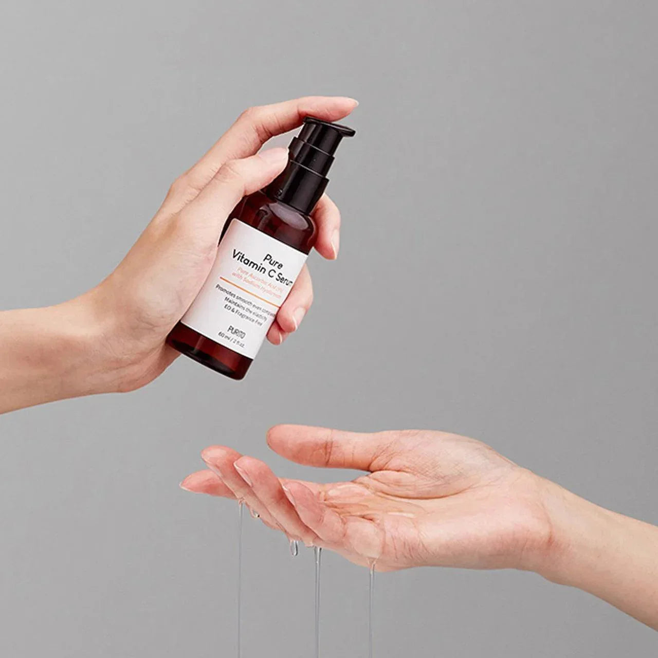 Hand applying Pure Vitamin C Serum skincare with dropper, Korean beauty product