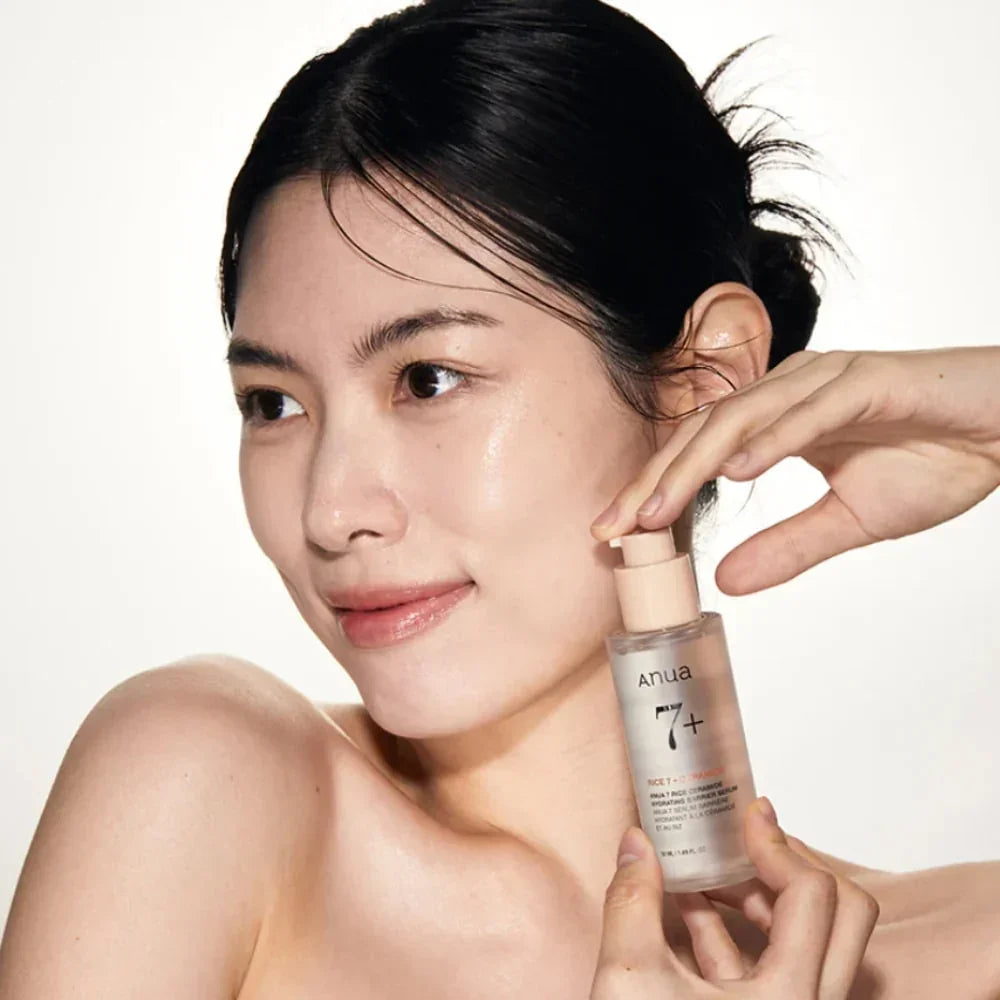 Woman applying Anua 7+ Rice Ceramide Hydrating Serum for glowing Korean skincare routine