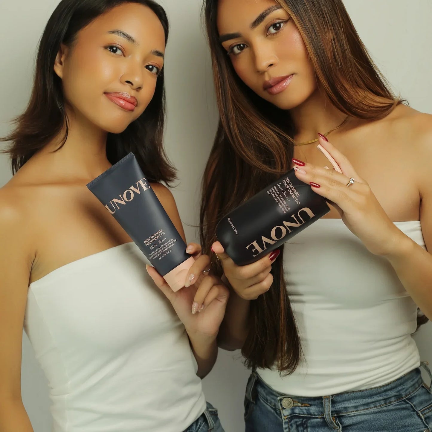 Two women showcasing UNOVE deep damage repair shampoo and treatment for healthy, radiant hair care.